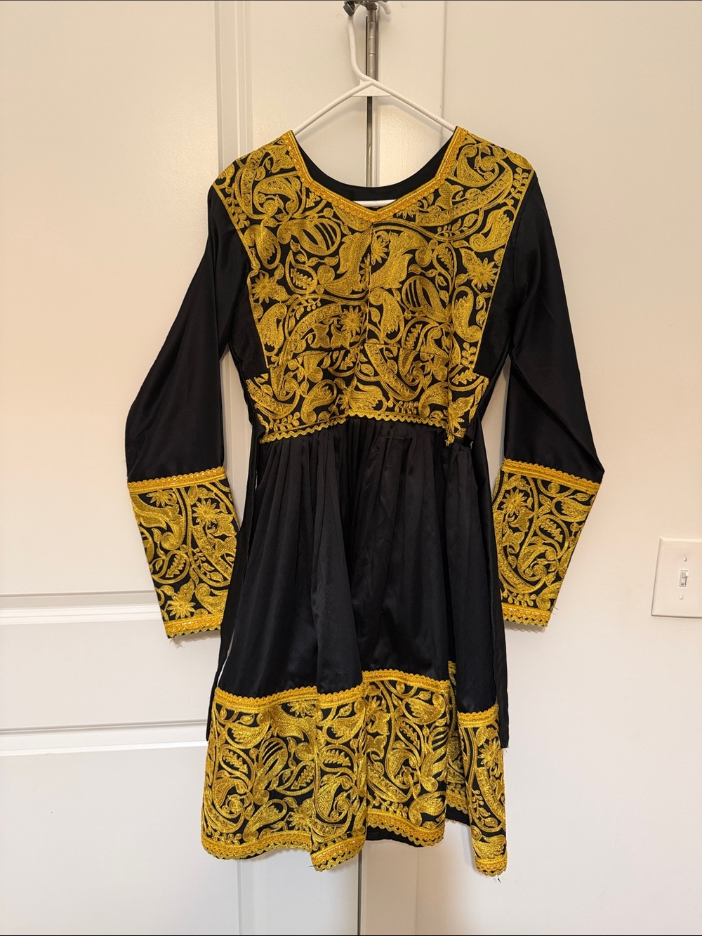 Traditional black and gold Afghan dress with red scarf